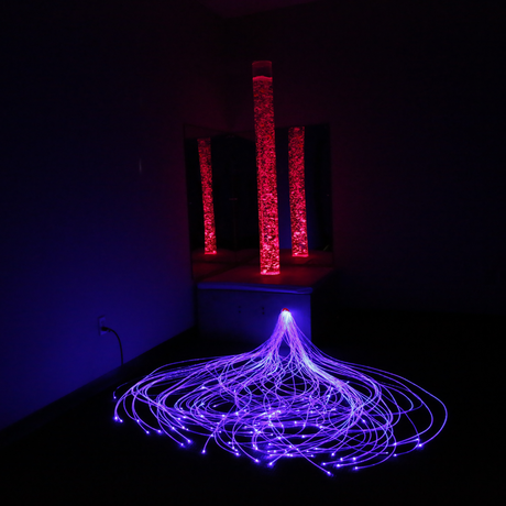 Artistic installation with glowing purple and red lights in a dark room