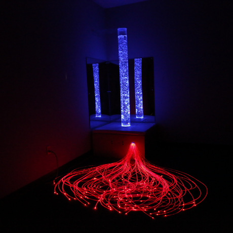 fiber optic bubble tube platform with red and blue lights in a dark room